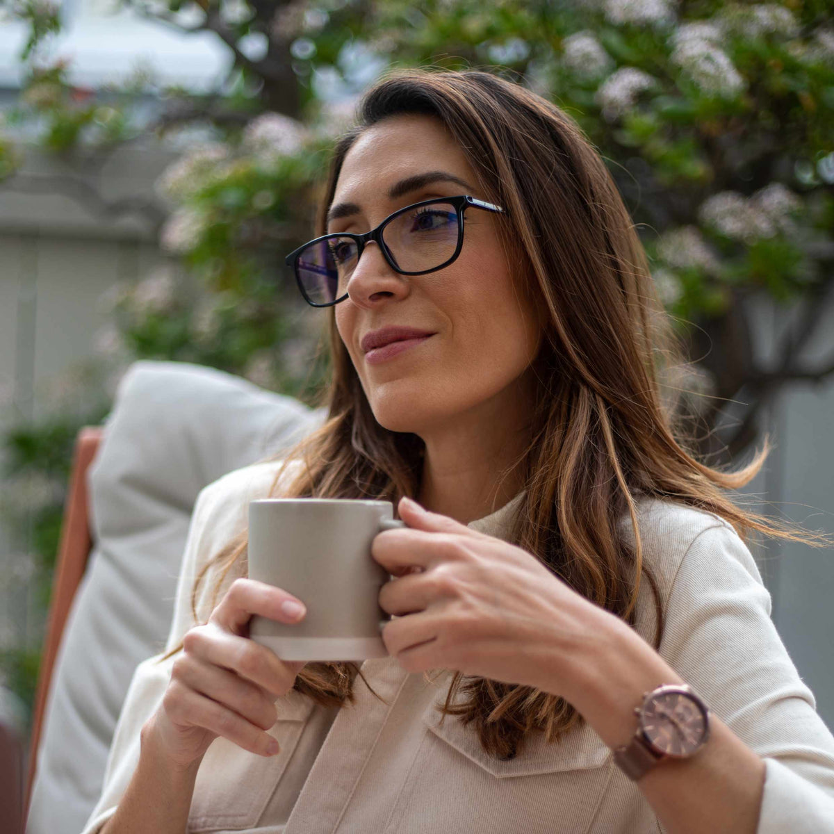 Woman holding a mug outdoors with blurred background