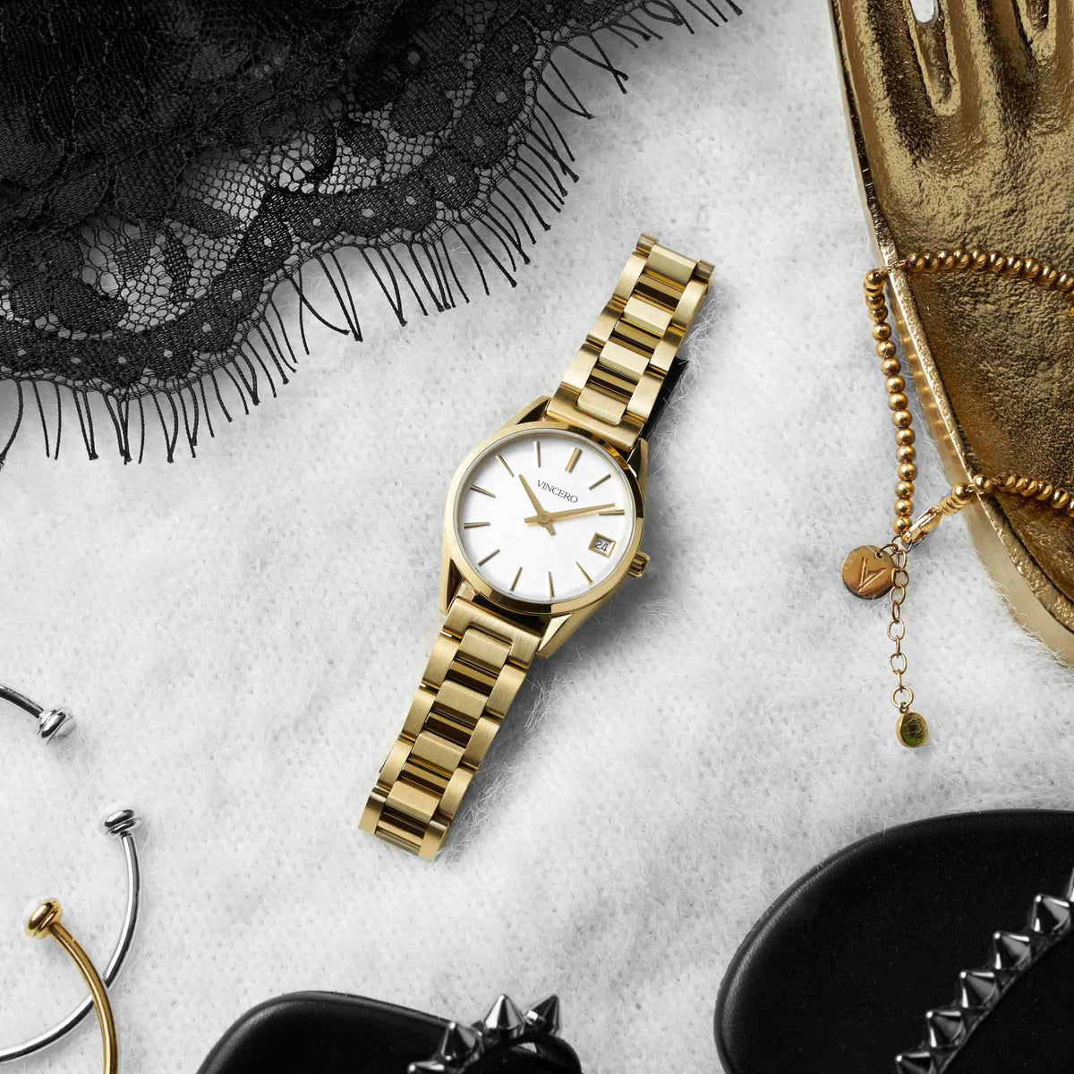Gold watch on a textured surface with decorative items