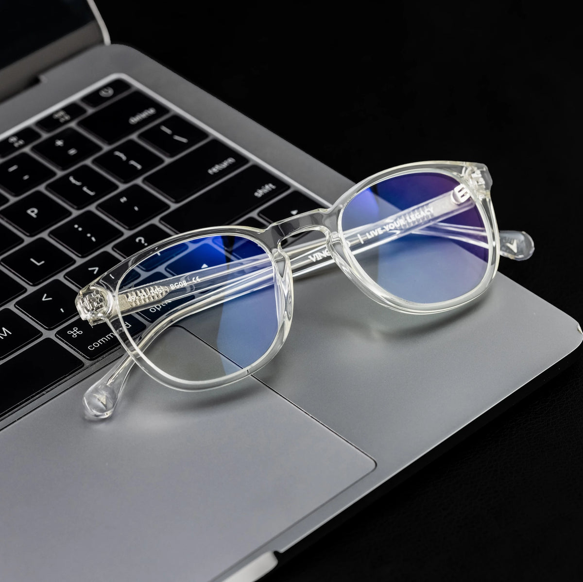 Clear sunglasses with blue lenses on a laptop keyboard