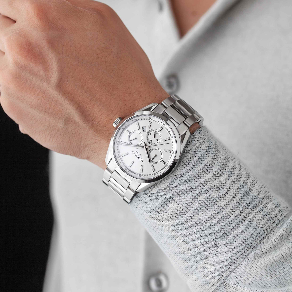 Silver wristwatch on a person's wrist with a light gray shirt