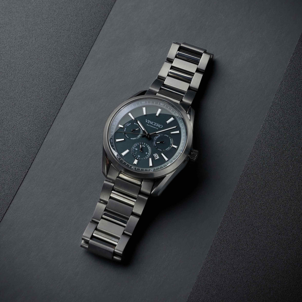 Silver watch with a dark face on a gray background