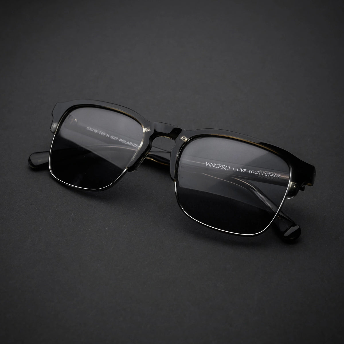 Black sunglasses with reflective lenses on a dark gray background