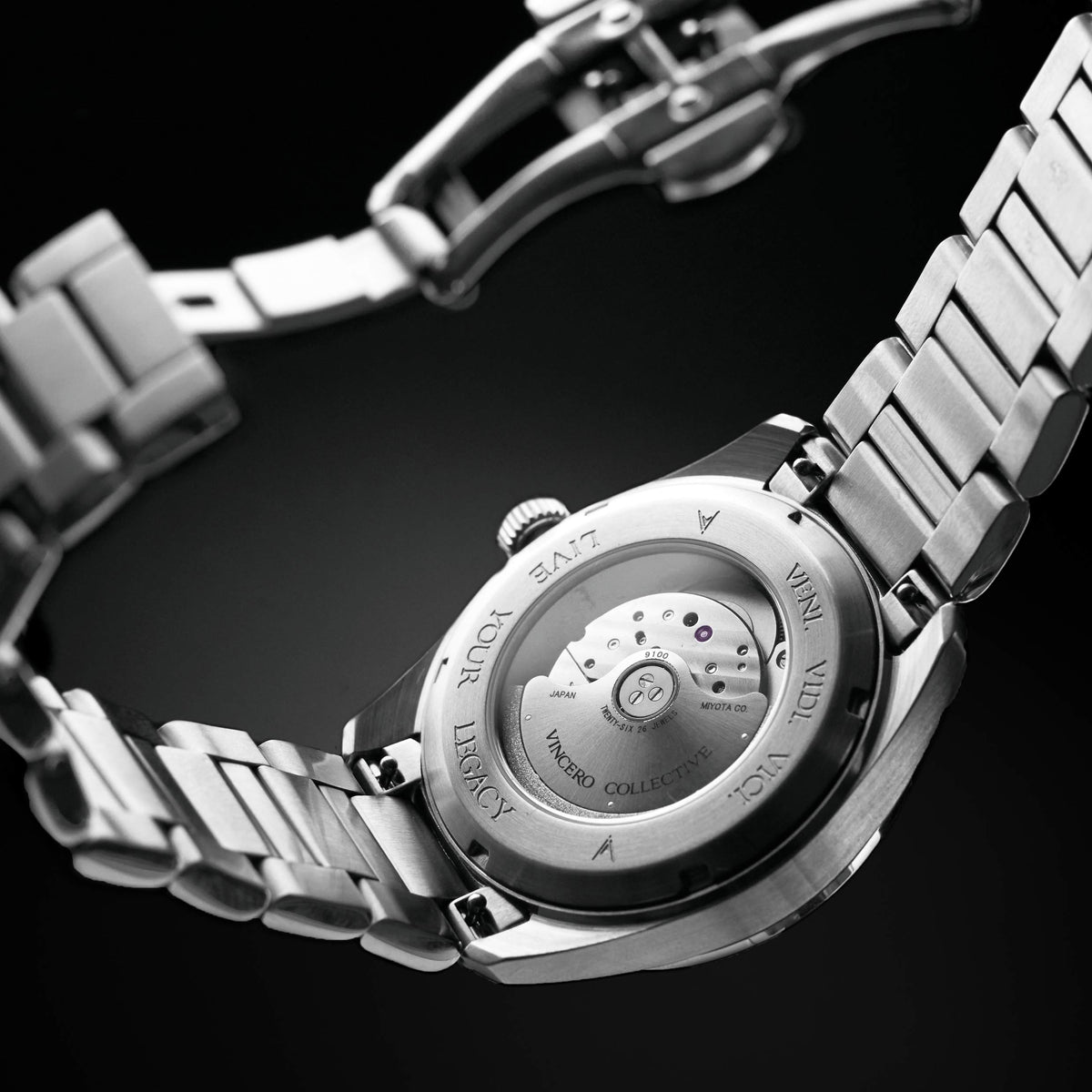 Close-up of a silver watch with visible brand name on a black background