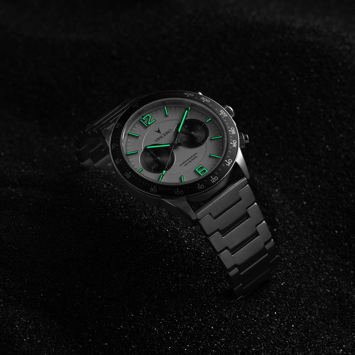 Black wristwatch with green accents on a dark textured background
