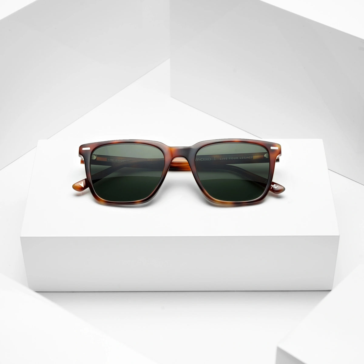Sunglasses with tortoiseshell frame and dark lenses on a white background