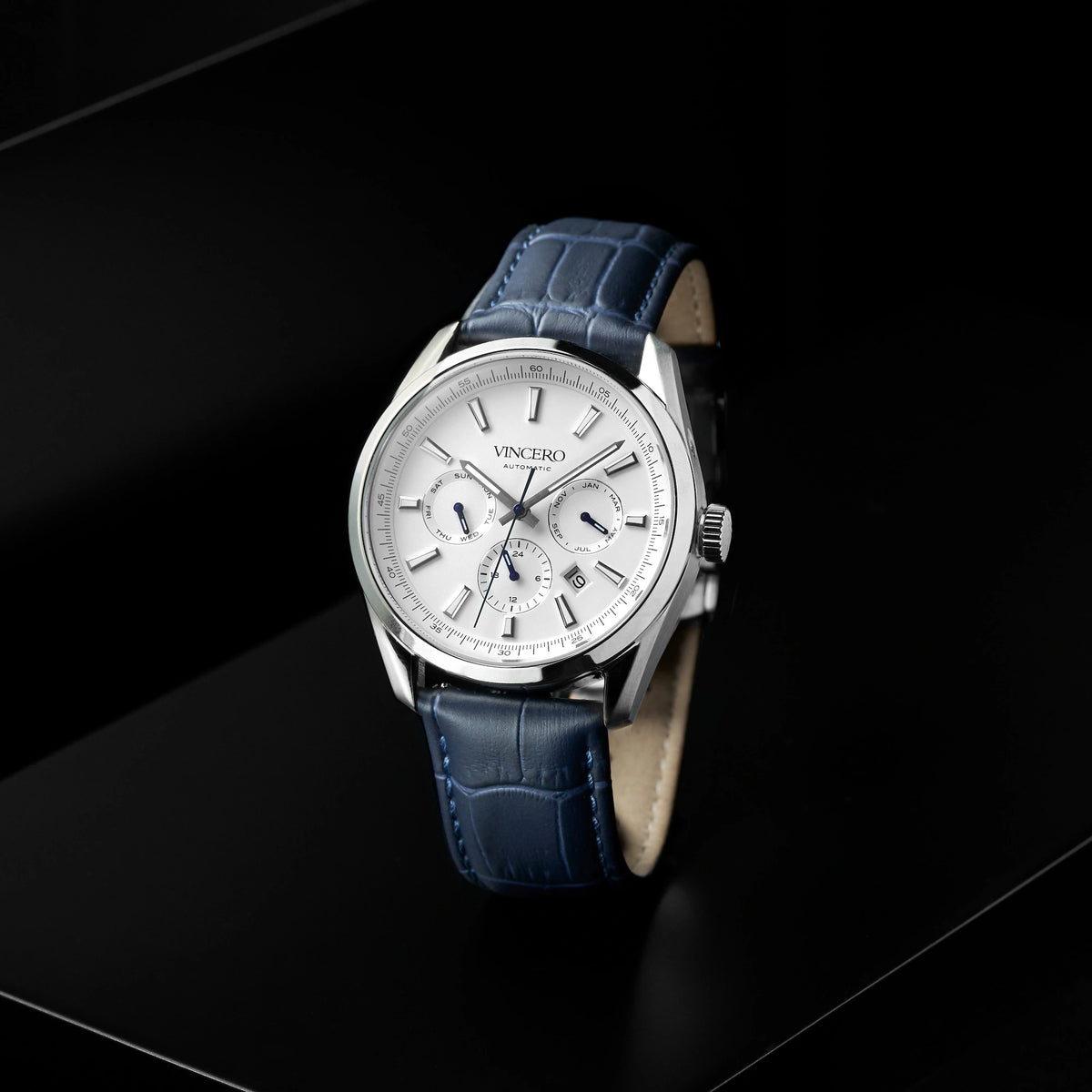 Watch with blue leather strap and white dial on a black background