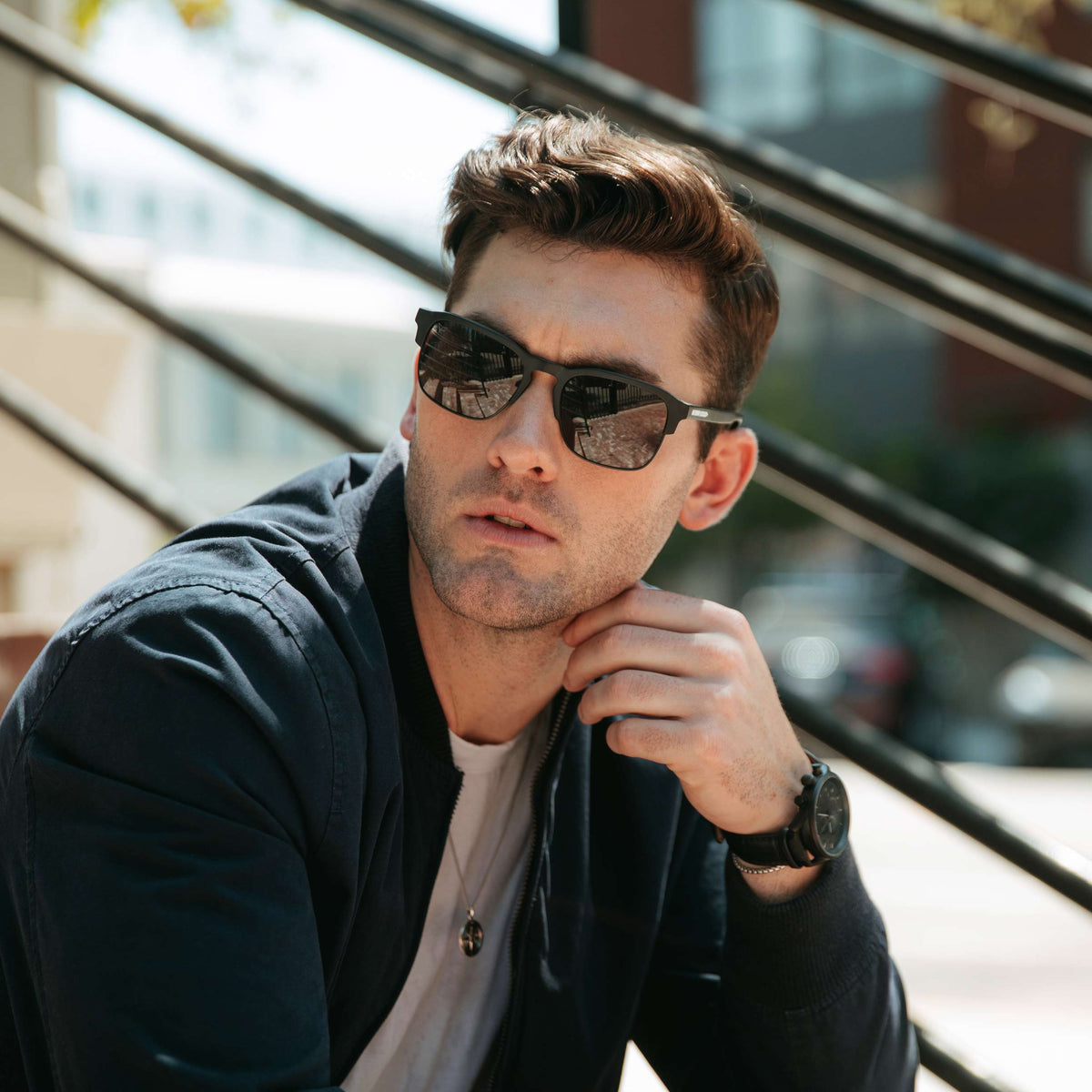 Man wearing sunglasses with a blurred urban background