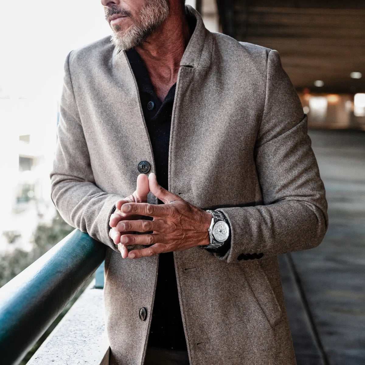 Man wearing a gray coat with a blurred background