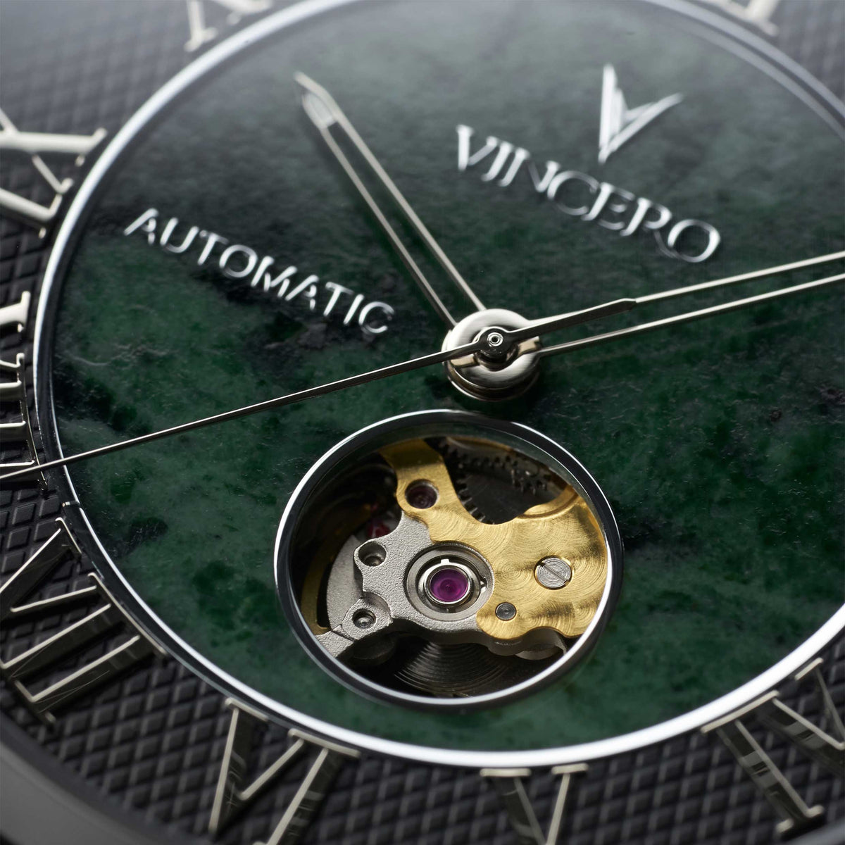 Close-up of a Vincepo watch with visible mechanical components and green dial.