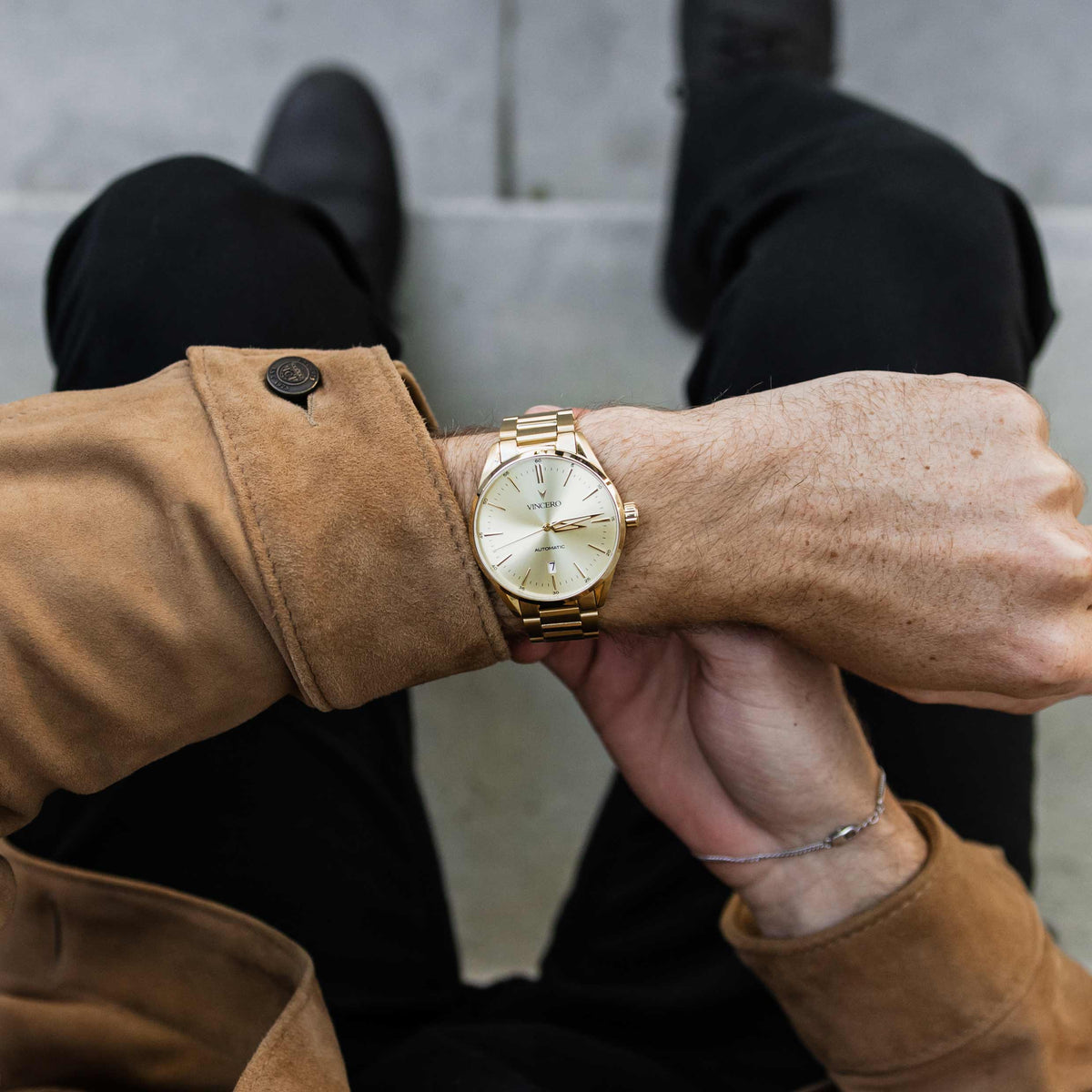 Gold wristwatch on a person's wrist with a blurred background