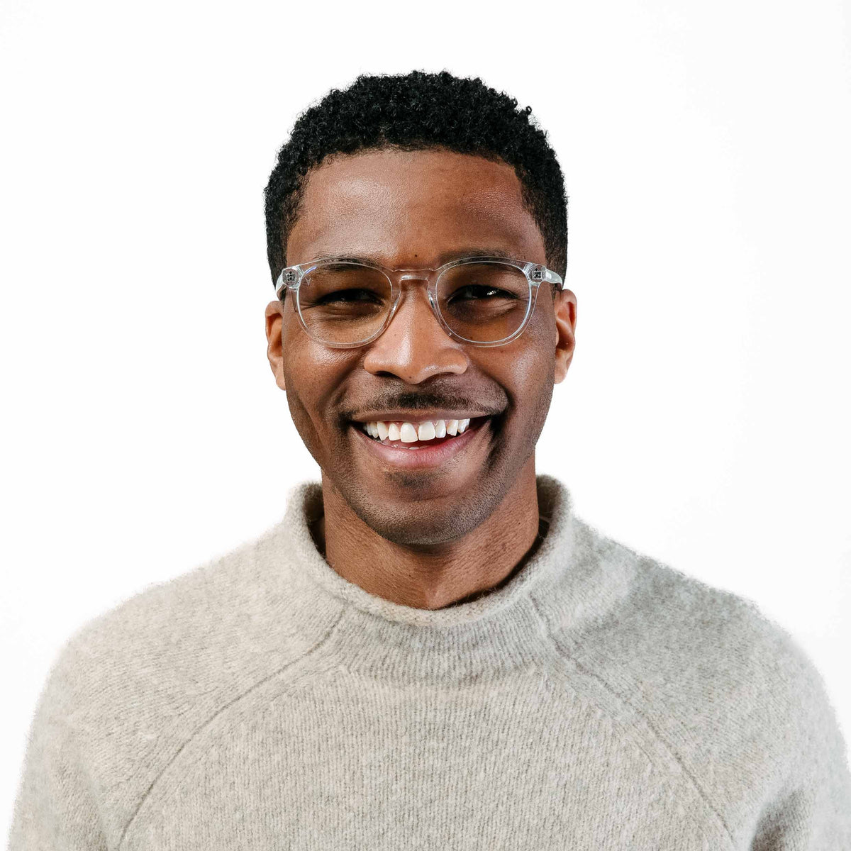 Man wearing glasses and a light gray sweater on a white background