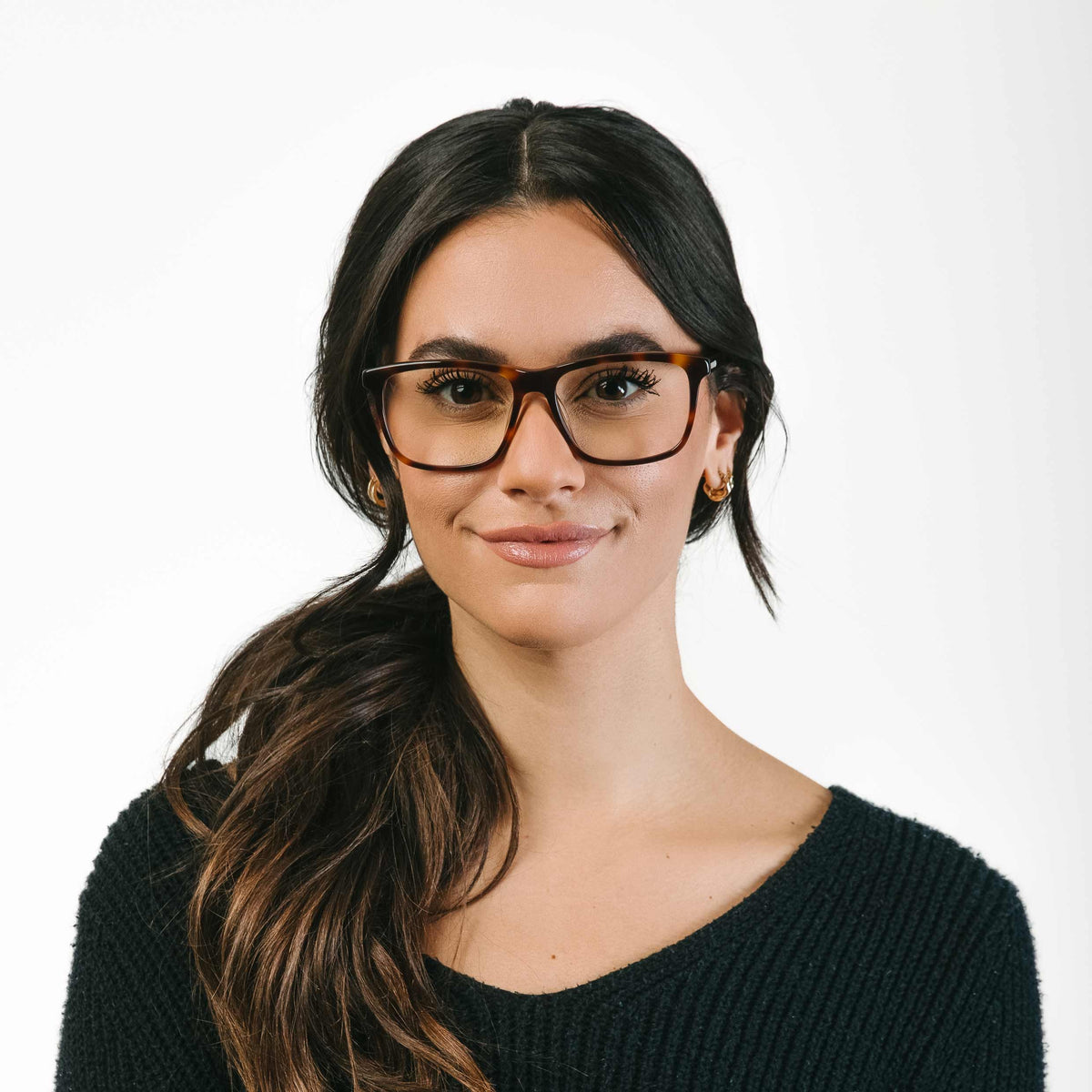 Woman wearing glasses and a black sweater on a white background