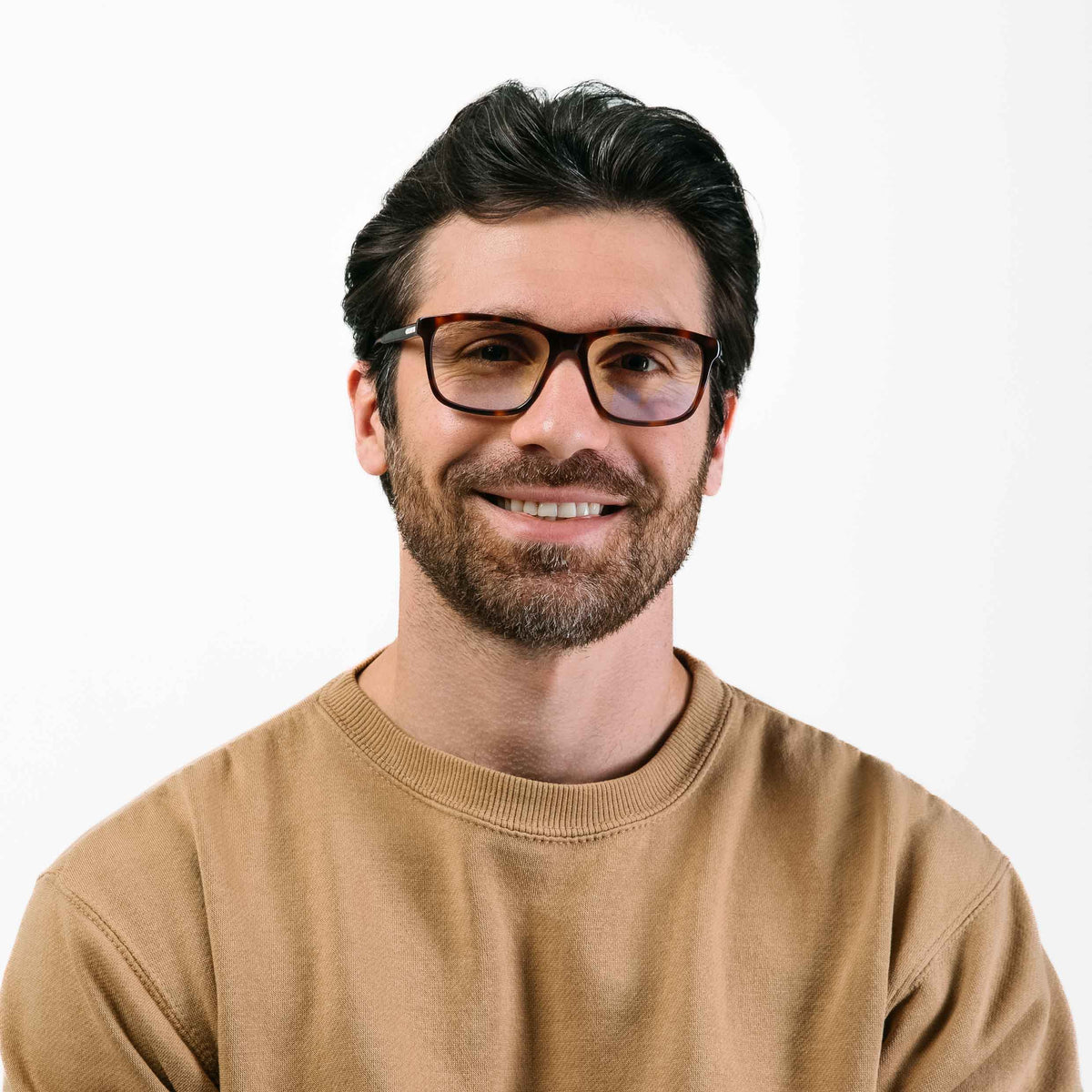 Man wearing glasses and a brown sweater on a white background