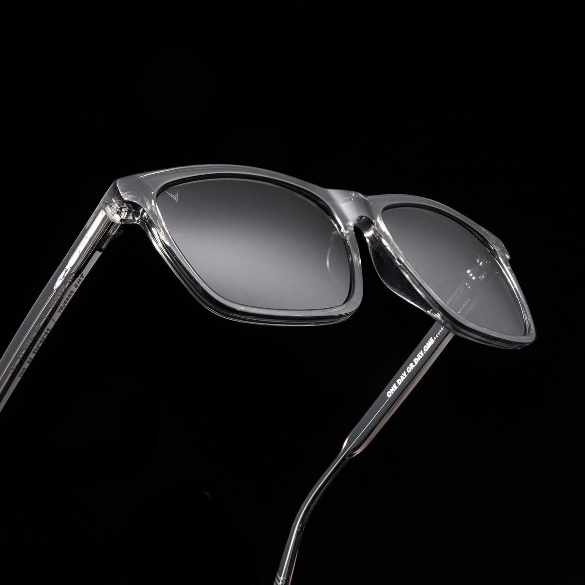 Clear sunglasses with dark lenses on a black background