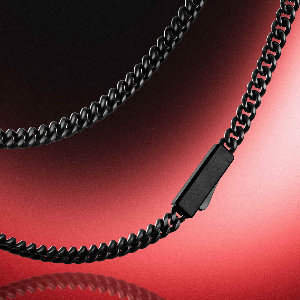 A close-up of a black metal chain necklace with a rectangular clasp, shown against a red-to-black gradient studio background.