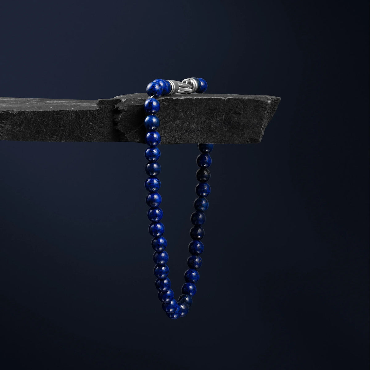 Blue beaded necklace on a dark background