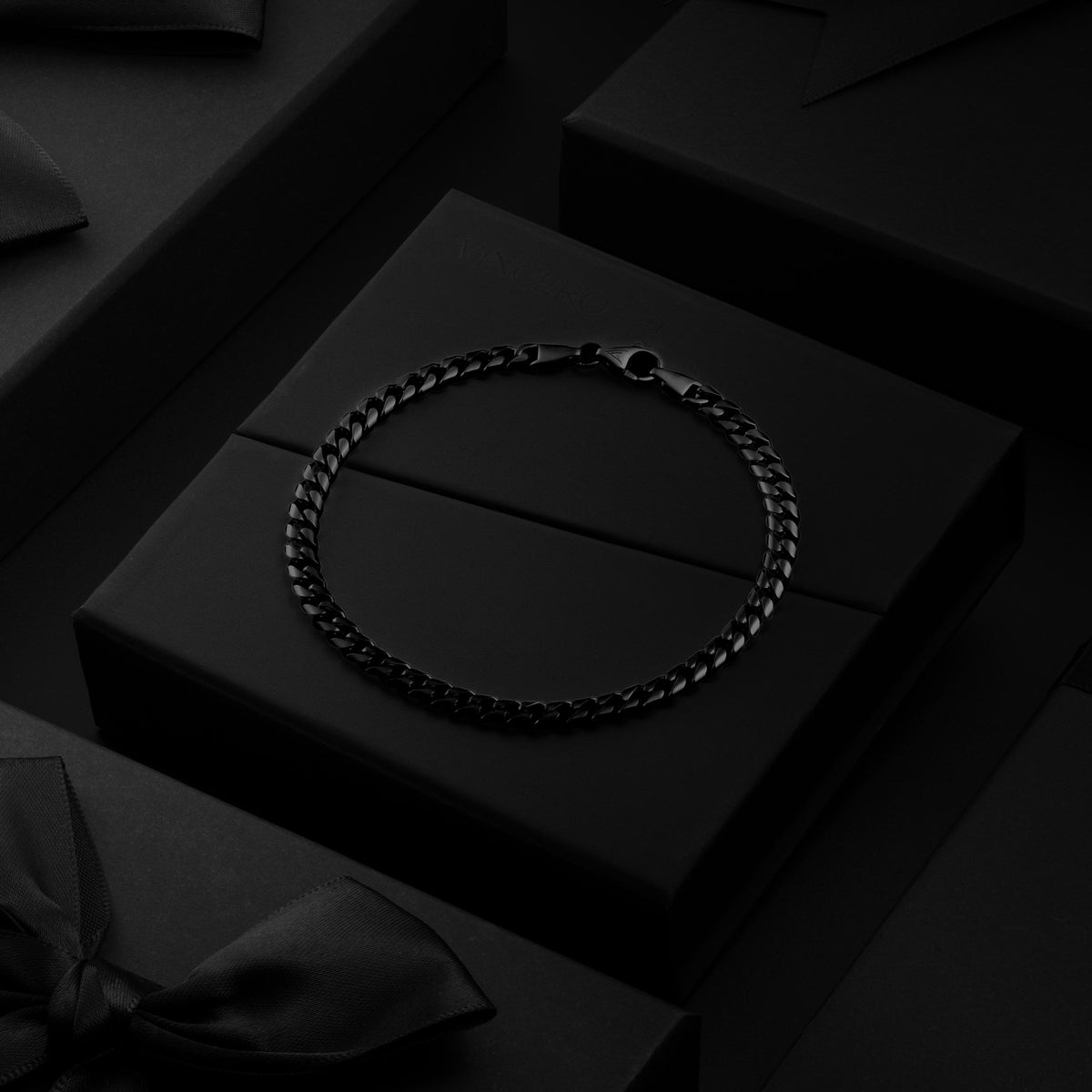 Black chain necklace on a black box with a dark background