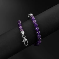 Purple beaded bracelet with silver clasp on a dark surface