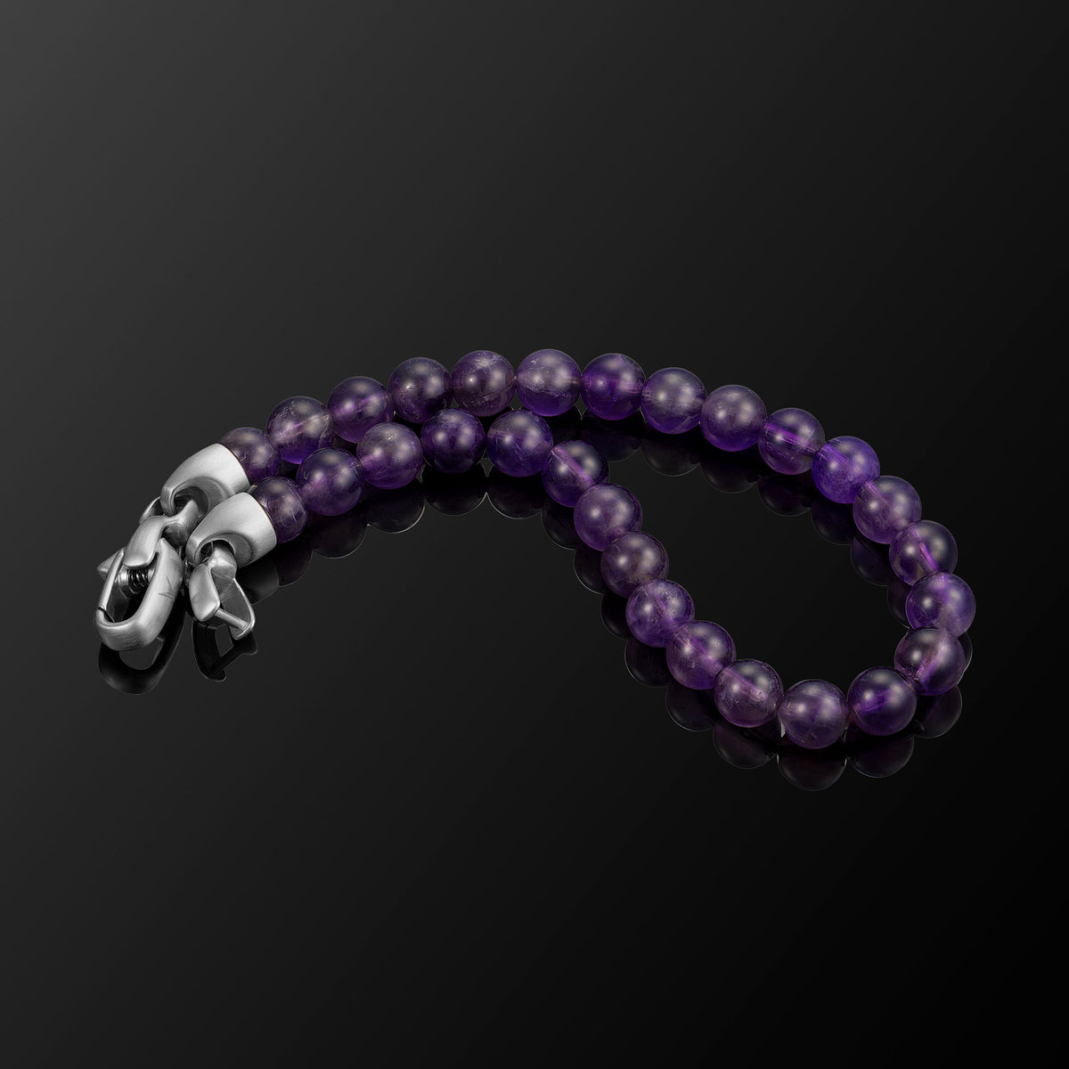 Purple beaded bracelet with a silver clasp on a black background