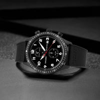Black wristwatch with detailed face on a dark background