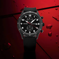 Black wristwatch with detailed face on a red textured background