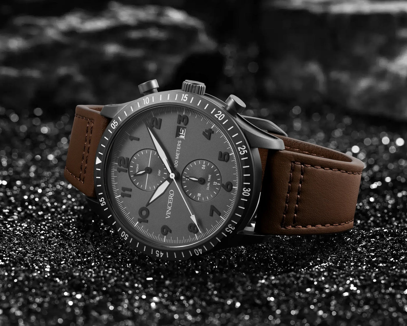 Wristwatch with brown leather strap on a dark textured surface