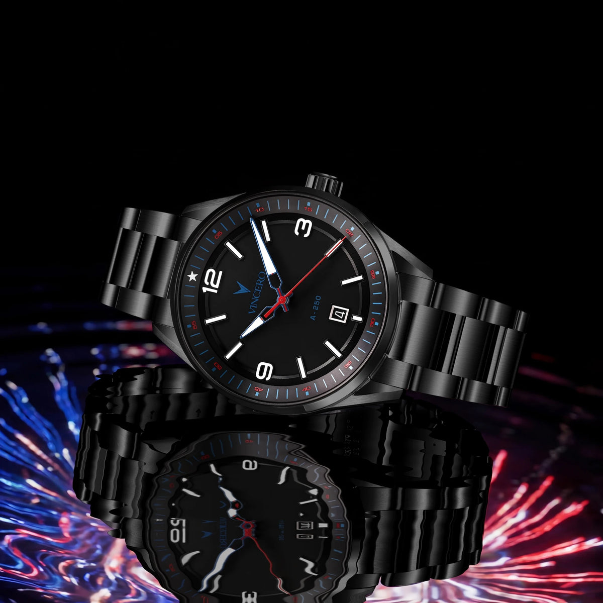 Two black analog wristwatches with black metal link bracelets and black dials, shown on a black background with a colorful blurred light effect at the bottom. The front watch is in sharp focus, and a second watch is reflected below.