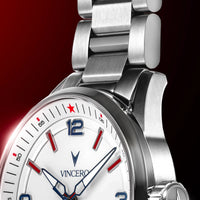 Close-up of a Vincero stainless steel watch with a white dial, featuring red and blue accents, a red star at the 12 o'clock position, and a matching steel link bracelet against a dark red background.