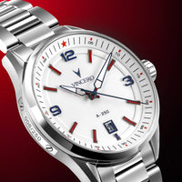A close-up studio shot of a Vincero A-250 stainless steel wristwatch with a white dial, featuring blue and red accents on the bezel and face, set against a dark red gradient background.
