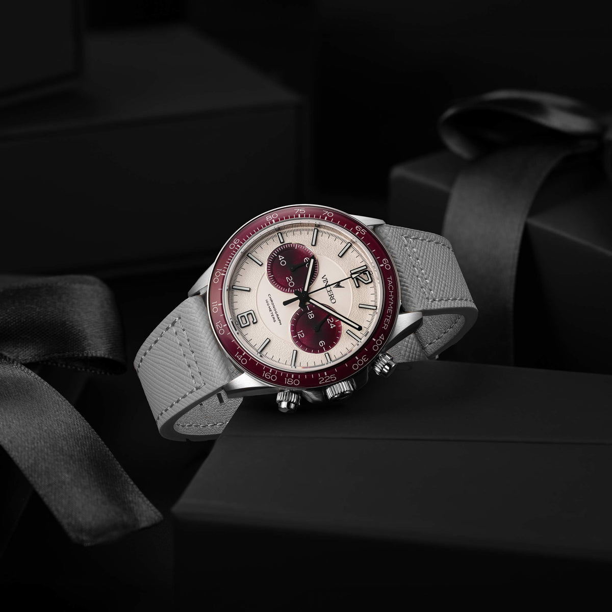 Luxury watch with red and silver design on a dark background