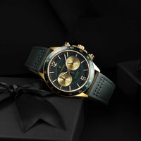 Luxury watch with green and gold face on a black background