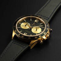 Luxury watch with black and gold face on a dark background
