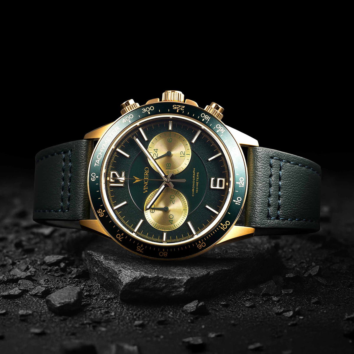 Luxury watch with green and gold face on a dark background