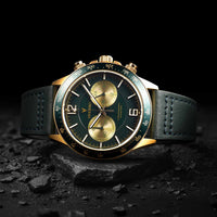 Luxury watch with green and gold face on a dark background