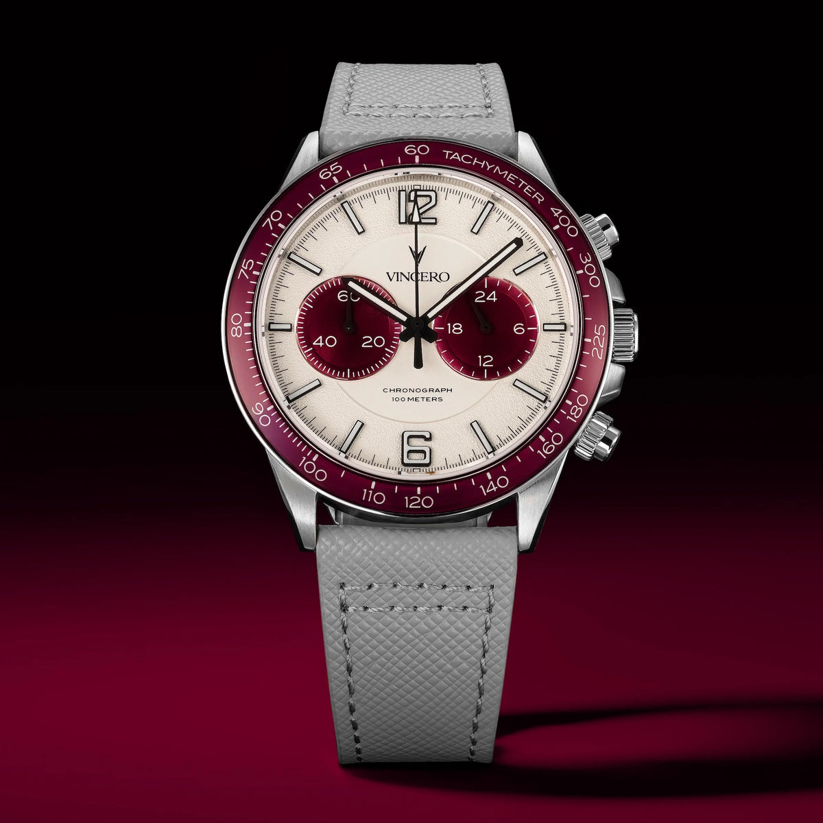 Watch with a gray strap and red and silver dial on a dark background
