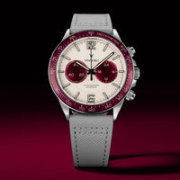 Watch with a gray strap and red and silver dial on a dark background