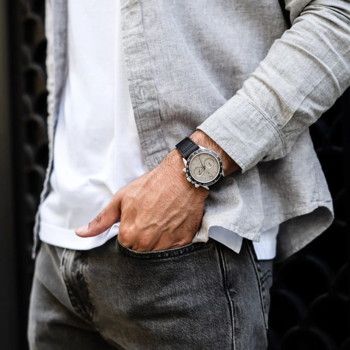 Person wearing a watch with a neutral background