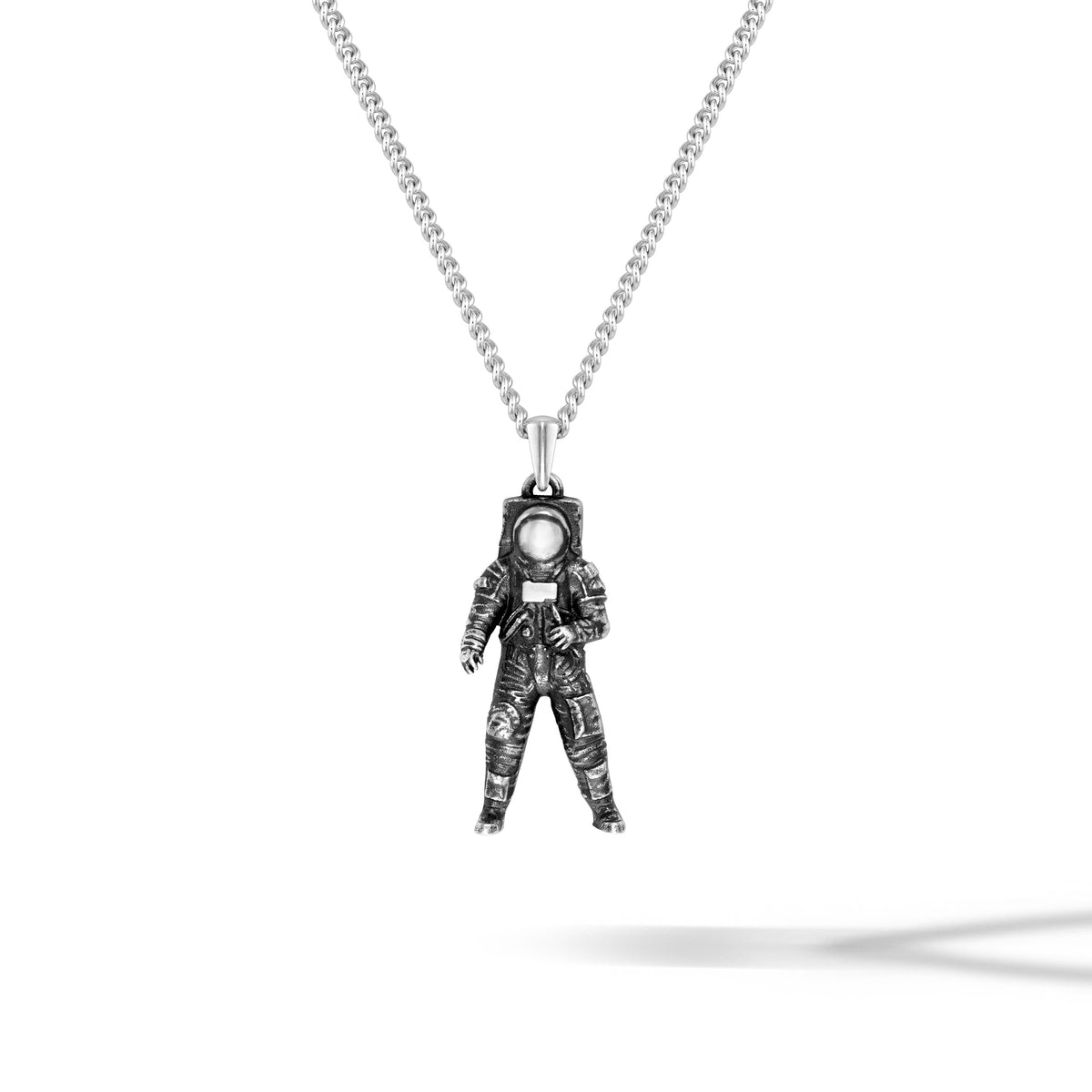 Astronaut pendant on a chain against a white background