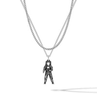 Silver astronaut pendant on a chain against a white background