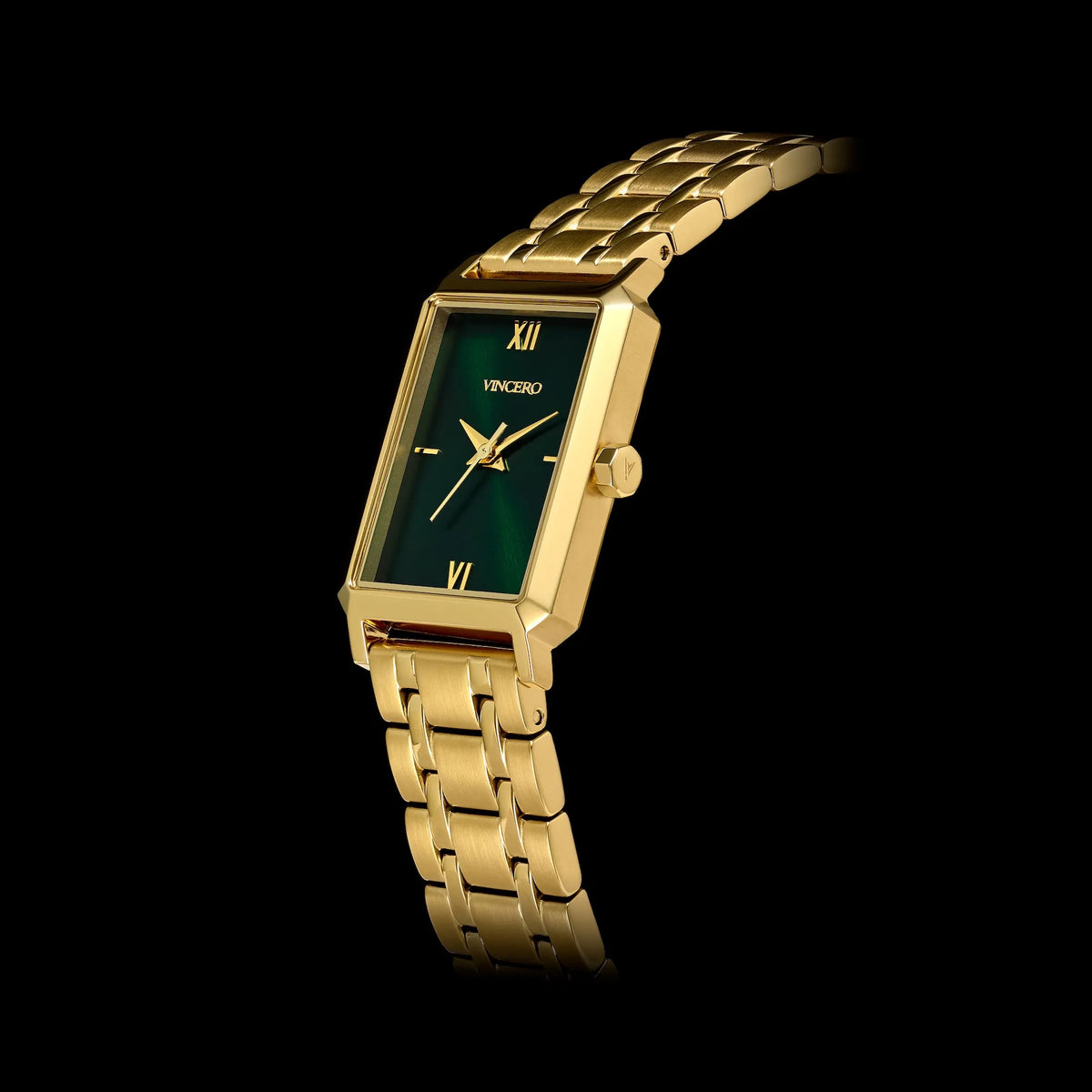 Gold wristwatch with a green face on a black background