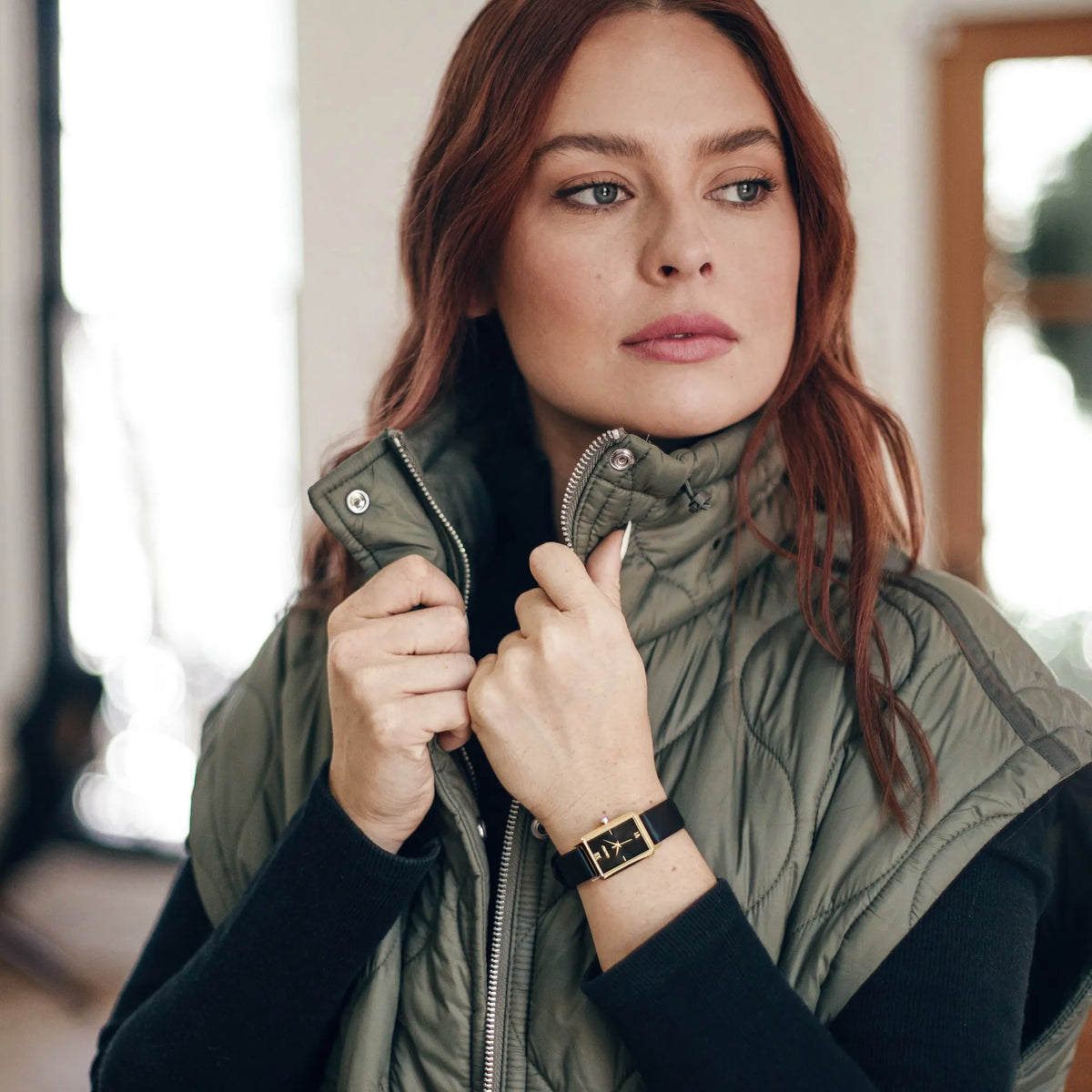 Woman wearing a green puffer vest indoors