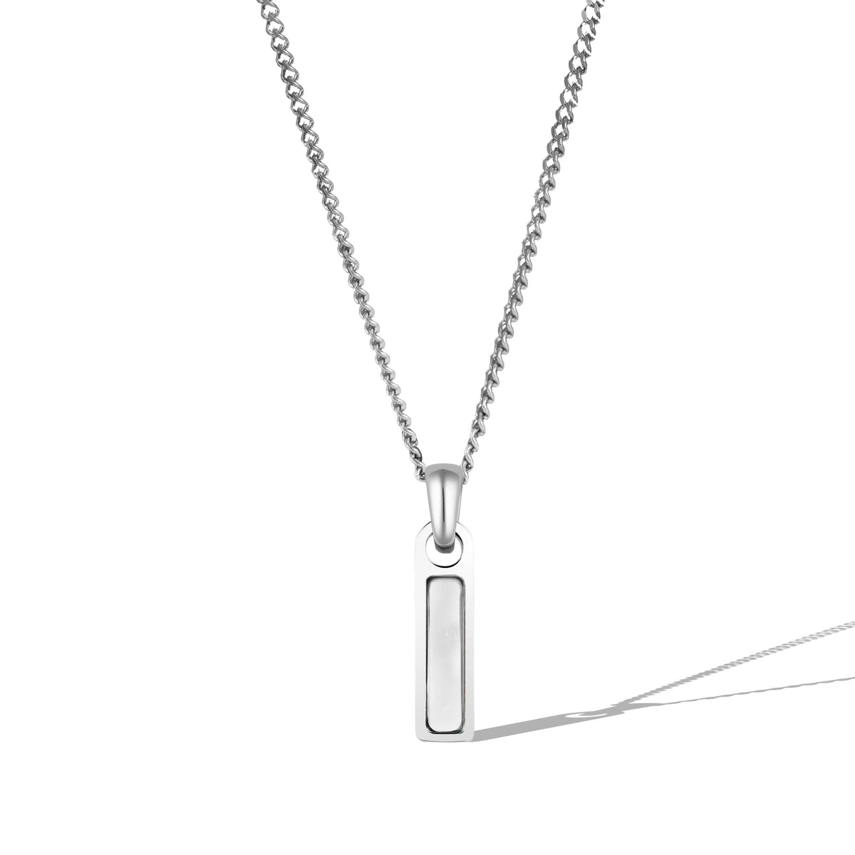 A silver necklace with a rectangular moonstone tag pendant attached to a chain.