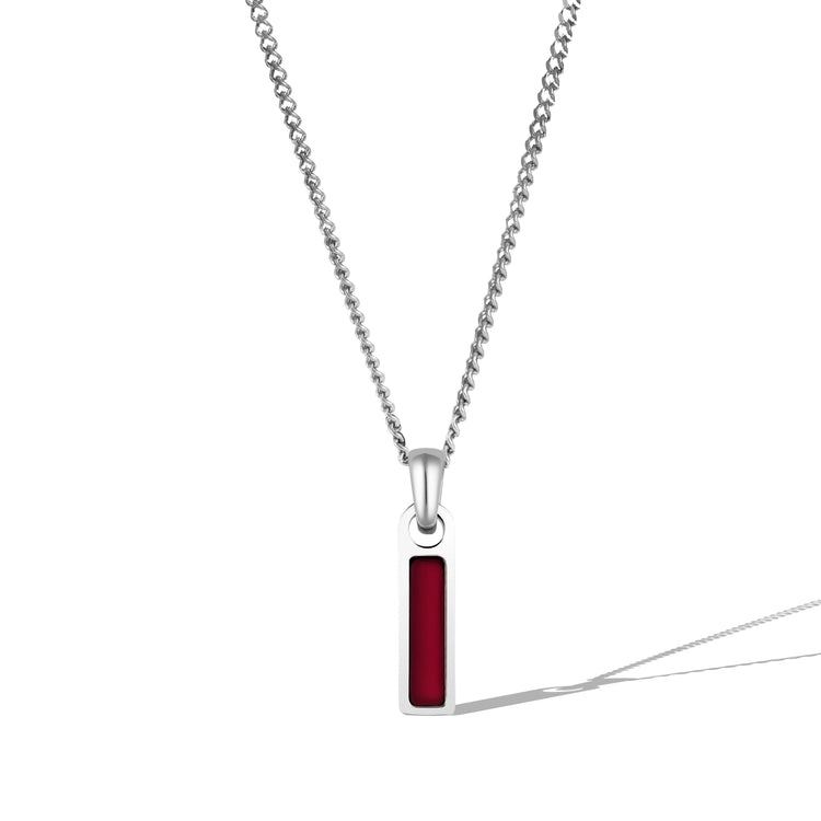 A silver necklace with a rectangular red tag pendant attached to a chain.
