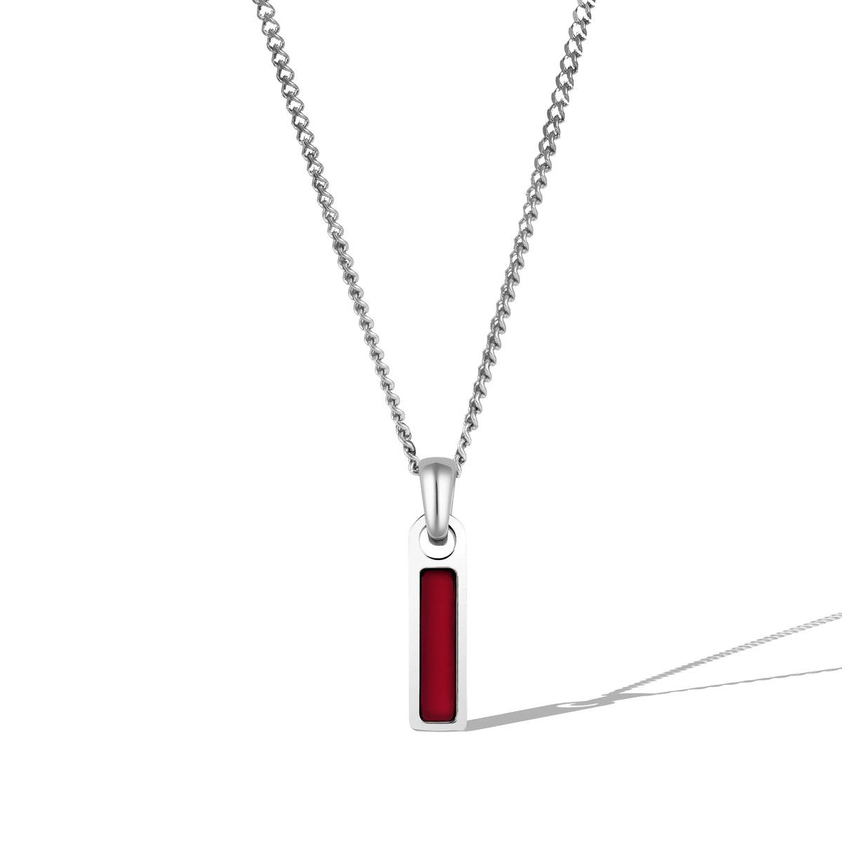 A silver necklace with a rectangular red tag pendant attached to a chain.