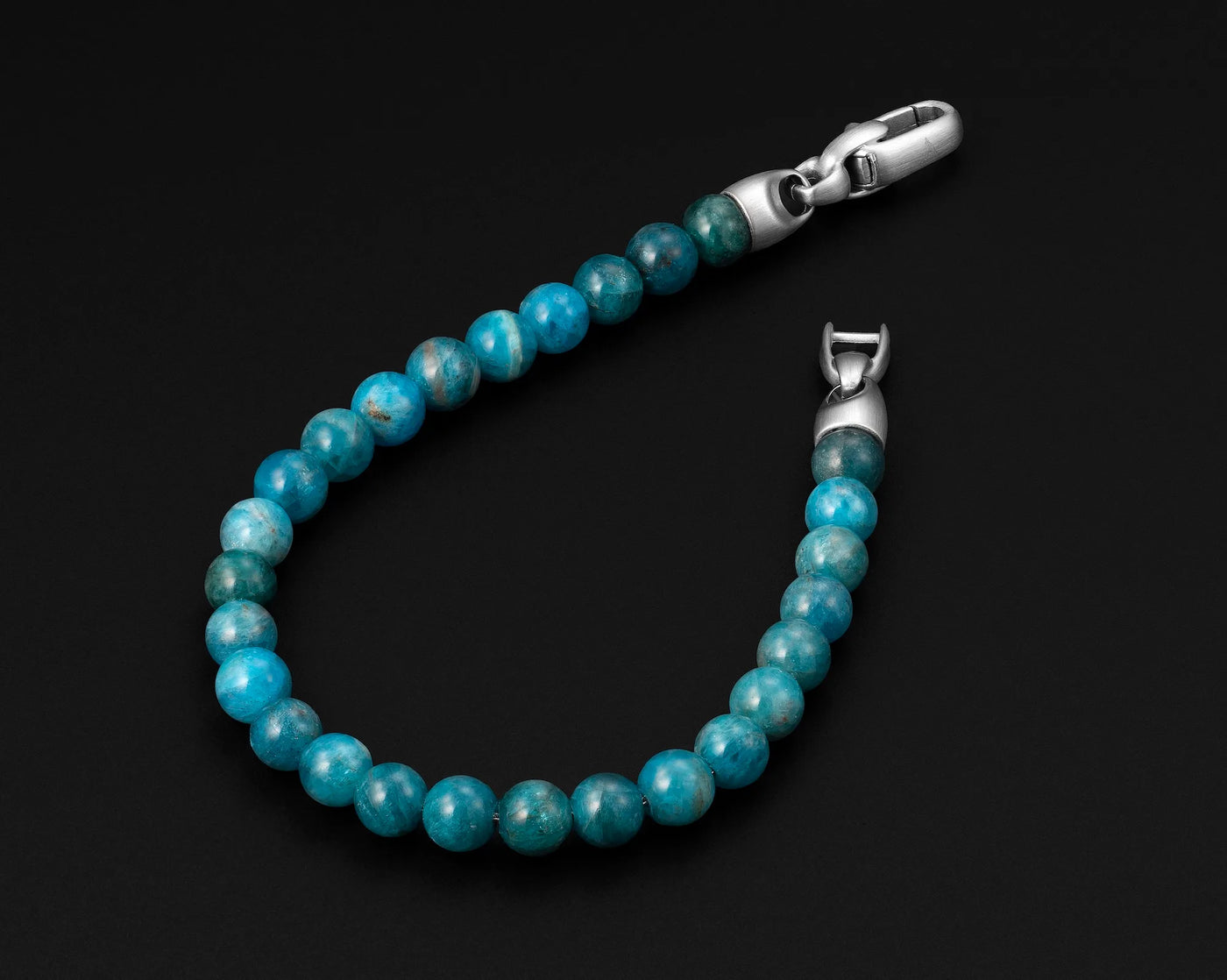 Turquoise beaded bracelet with silver clasp on a black background