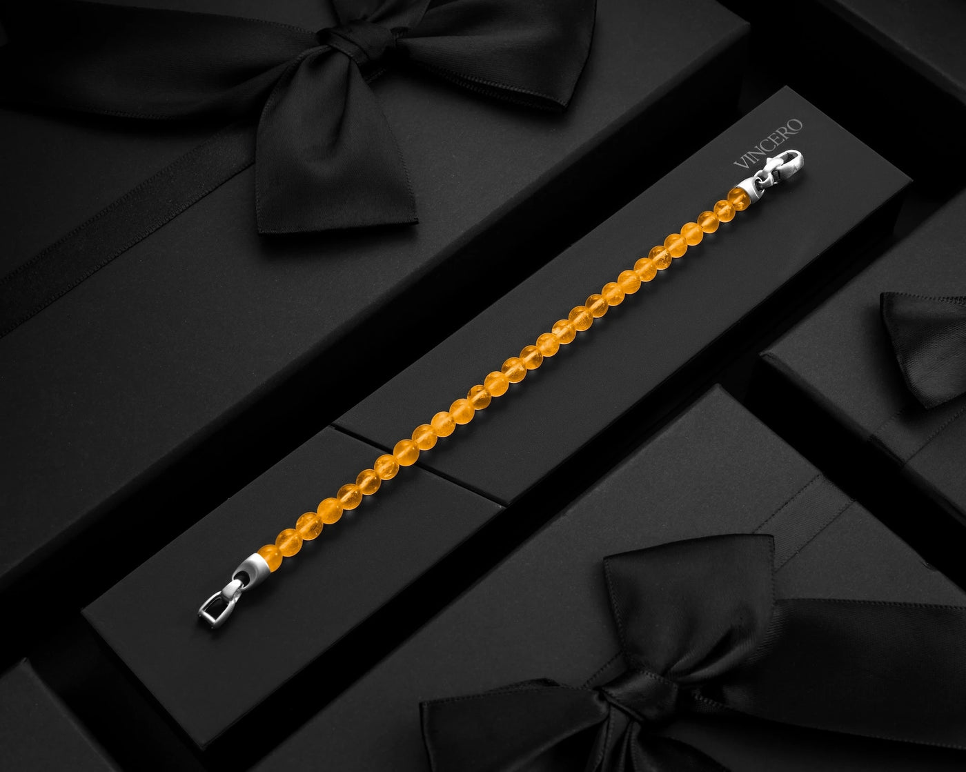 Yellow beaded bracelet with silver clasp on a black surface