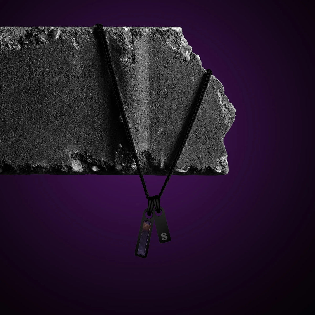 Black necklace with a pendant on a purple background