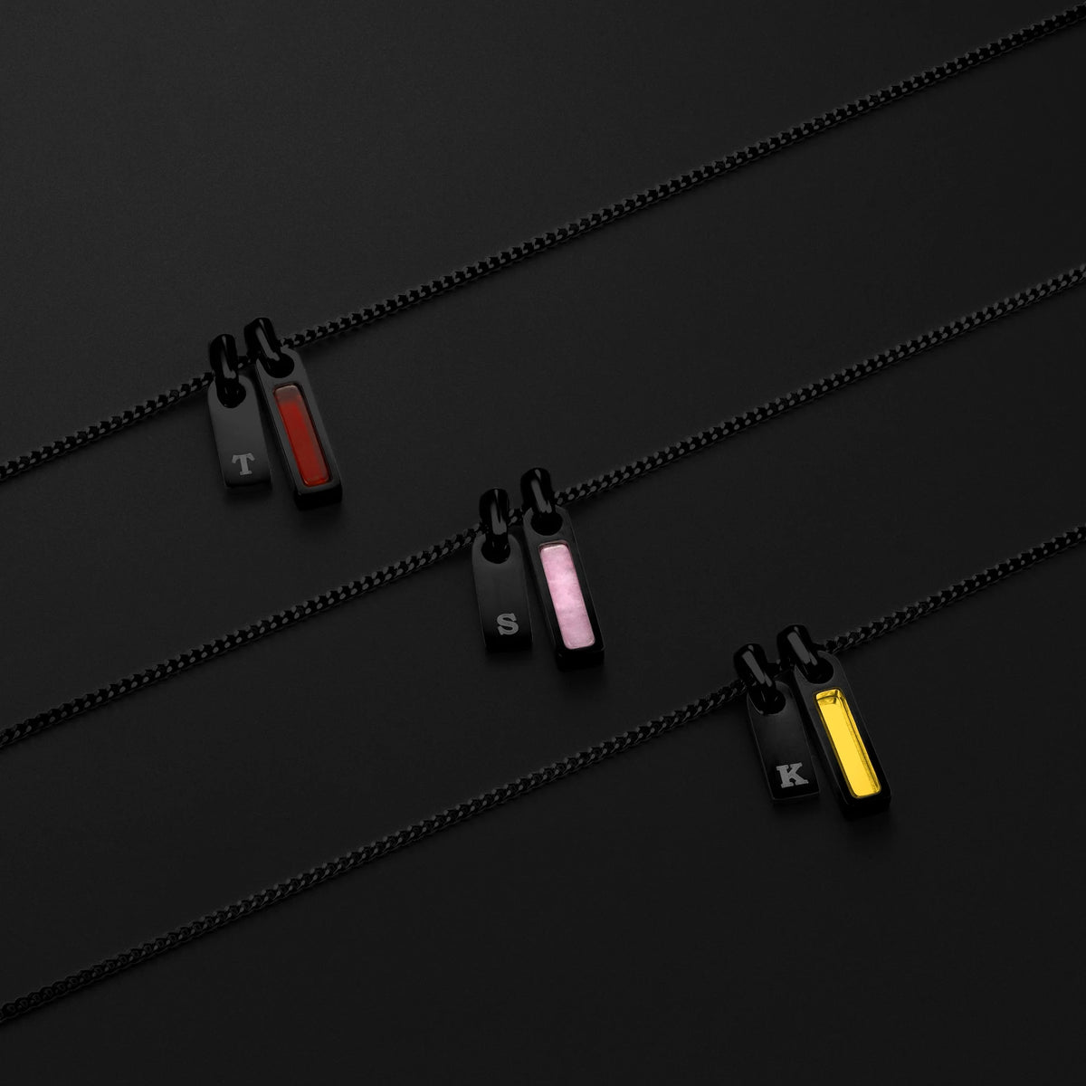 Three zipper pullers with different color options on a black background