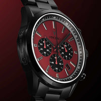 Black wristwatch with a red face on a dark background