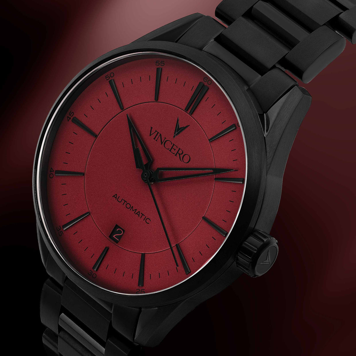 Black wristwatch with a red face on a dark background